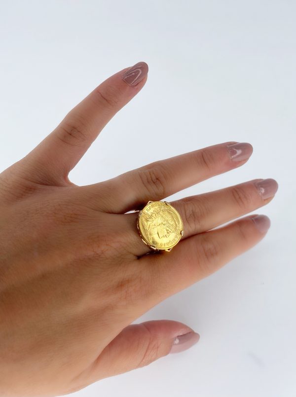 Mesure et art du temps -Gold coin of 20 francs mounted in ring. On the front : right profile of the Marianne wearing the phrygian cap and a crown of oak branch. Inscription : FRENCH REPUBLIC. On the reverse side the French motto : Liberty, equality, fraternity surrounds a rooster, date 1907. Engraver : Jules-Clément Chaplain. Edge with inscription LIBERTE EGALITE FRATERNITE. Mounting punched eagle head Size : 55 FR; 7 US; N UK